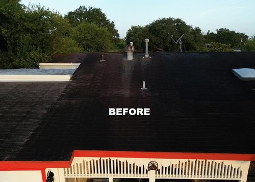 Worn out flat roof with weathered dark shingles before replacement